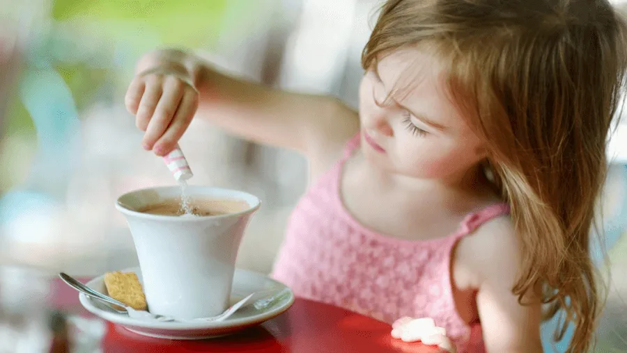 A young girl making a cup of coffee