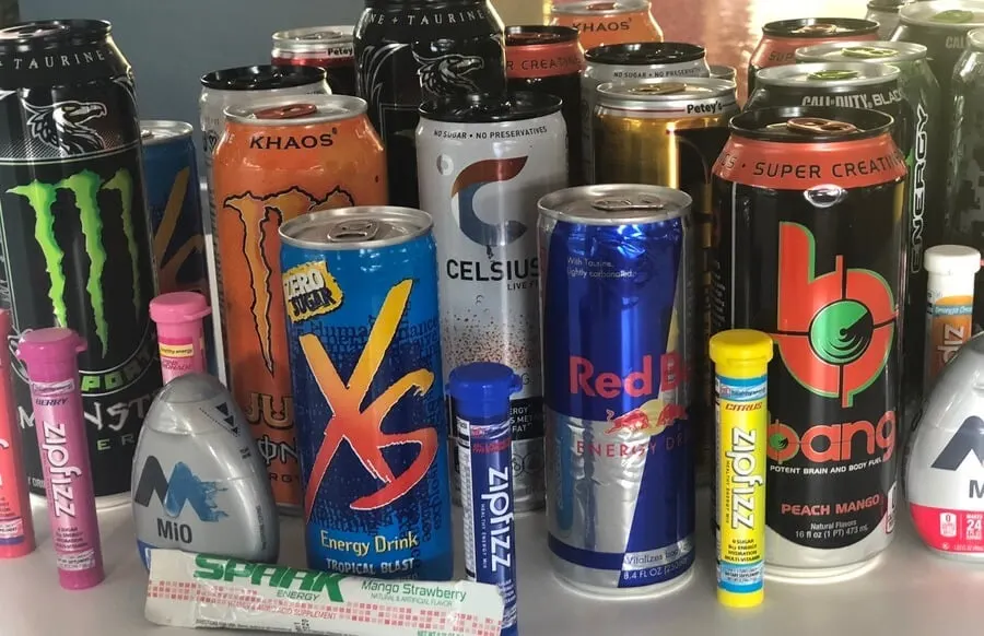 A close shot of many different brands of energy drinks.