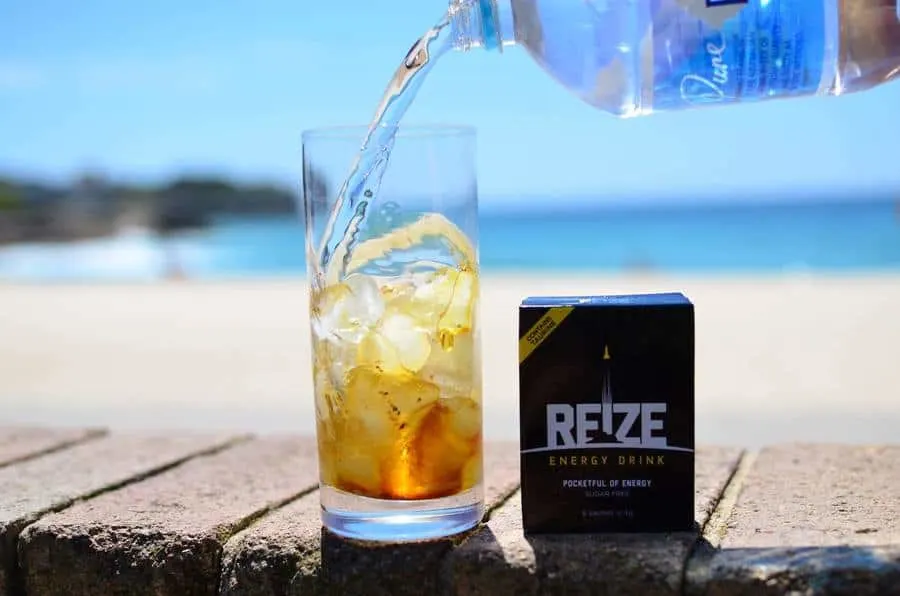packet of reize energy drink next to a glass of iced water