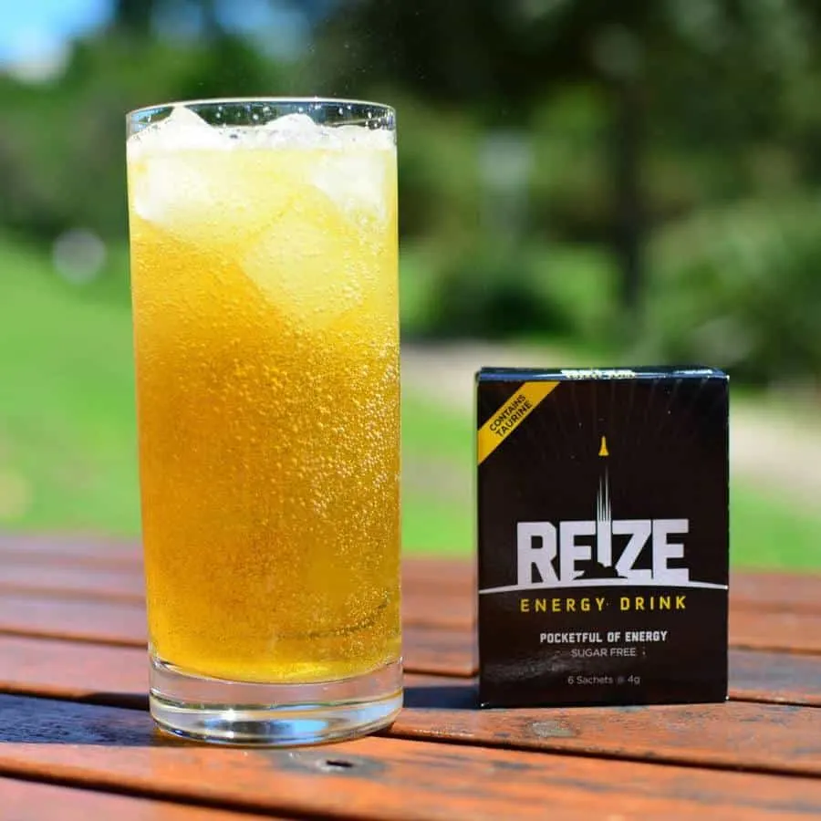 A packet of REIZE next to a ready made glass of REIZE energy drink