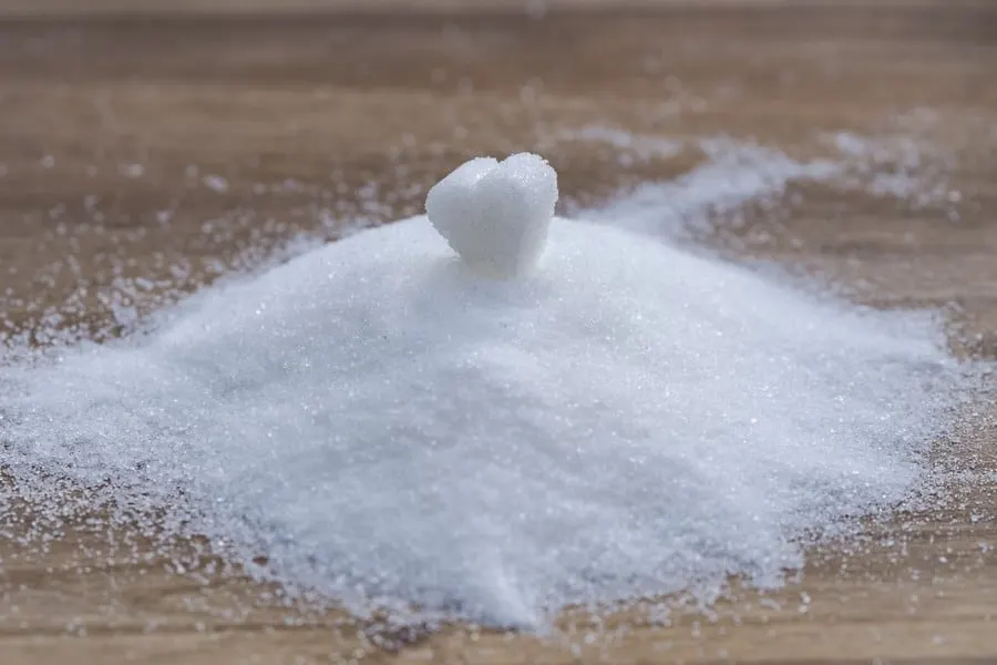 Grains of sugar in a table, heart shaped sugar at the top.