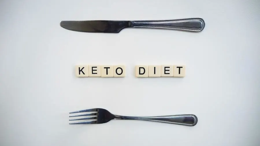 scrabble tiles spelling out keto diet between a knife and a fork.