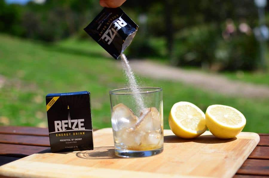Reize energy drink sachet being pured into a glass filled with ice