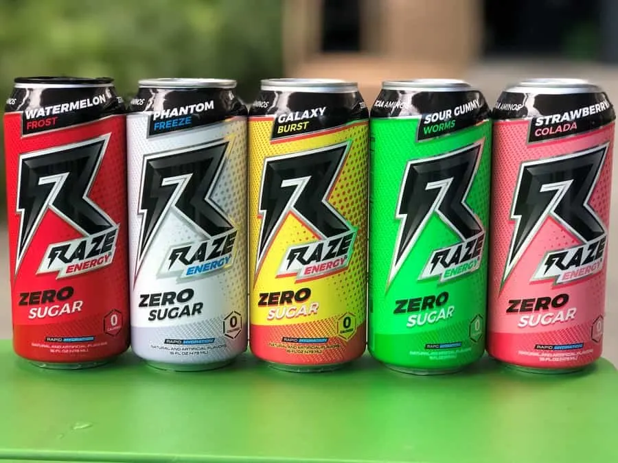 A selection of Raze energy drinks on a green table.