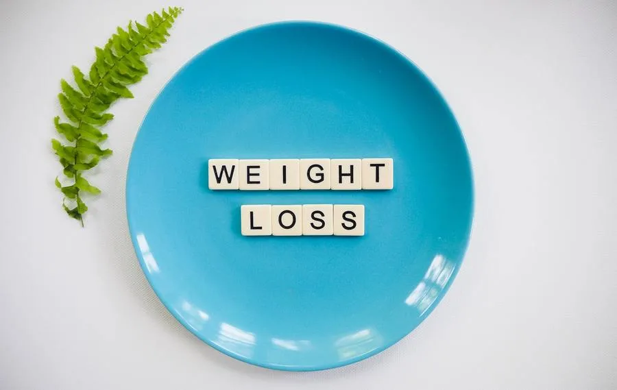 Blue plate with Scrable tiles spelling weight loss in the middle