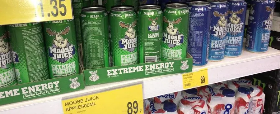 A lot of different Moose Juice energy drink cans on the shelf in a supermarket in the UK