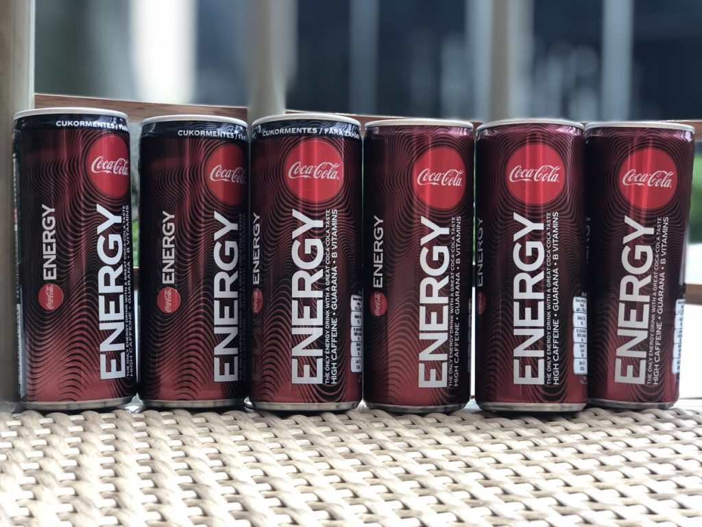 Five cans of Coca-Cola Energy on a table in full view.