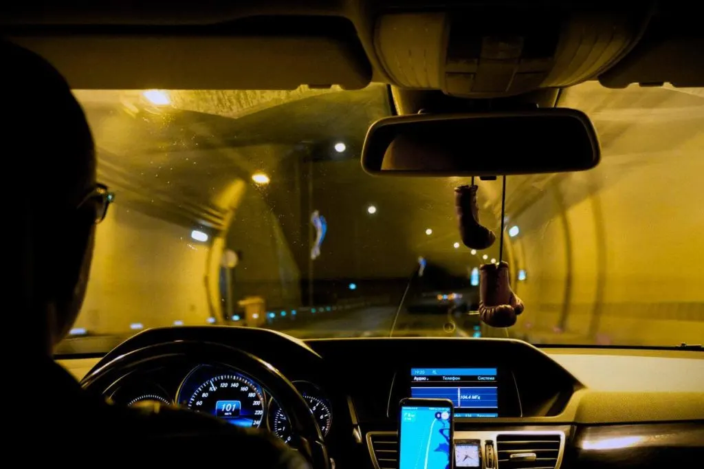 A picture of a man driving at night
