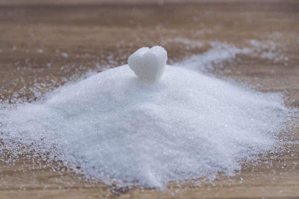 A pile of sugar with a sugar heart at the top. 