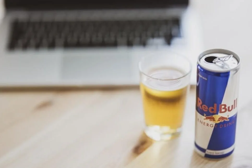 Red Bull in front of a laptop.