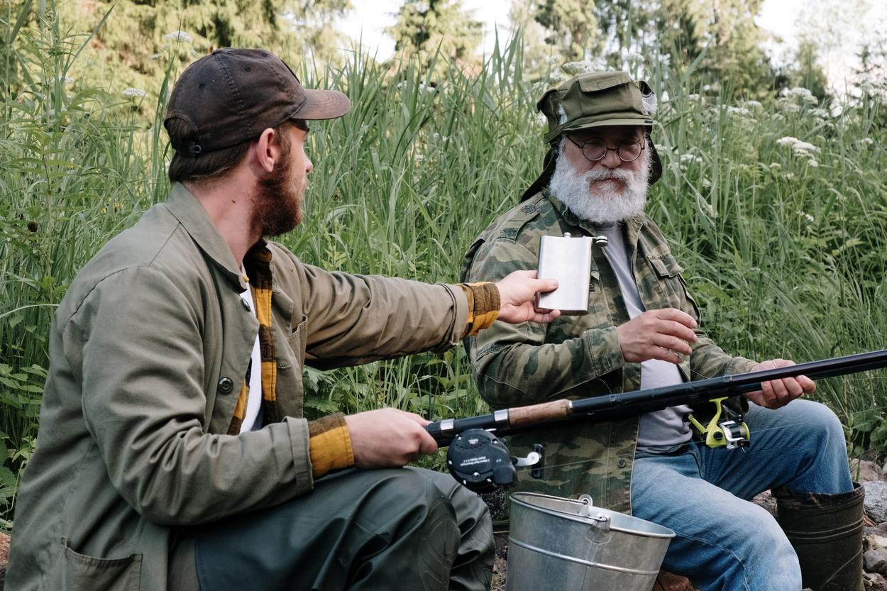 Two men drinking while fishing