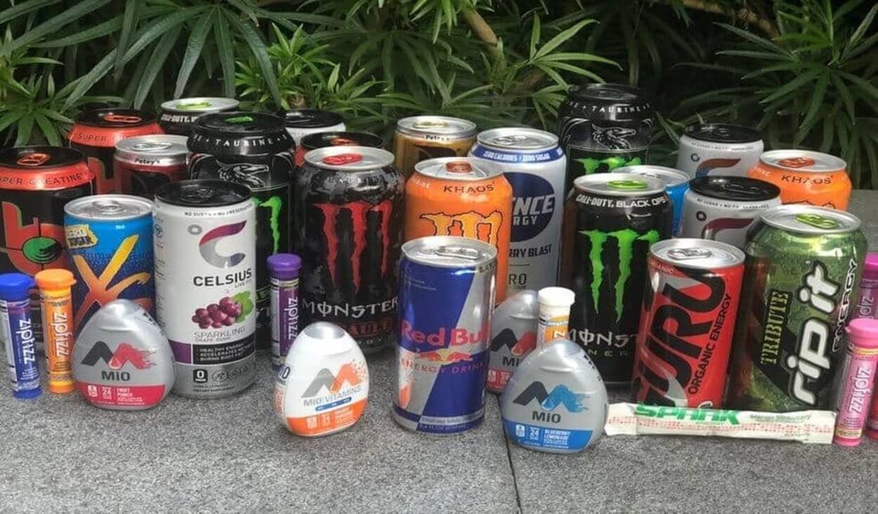 Different energy drinks brands arranged together on a pavement